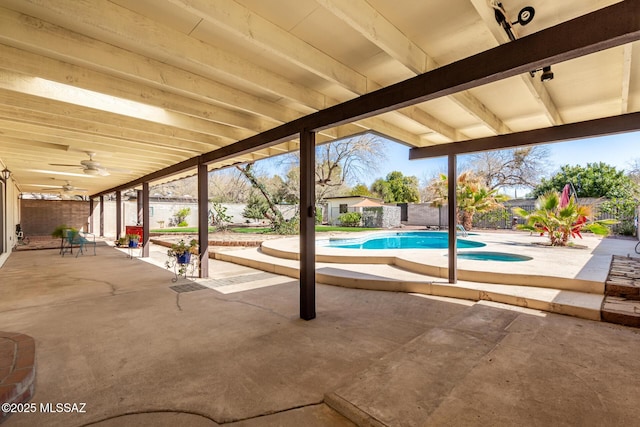 view of swimming pool featuring a fenced in pool, a patio, and a ceiling fan