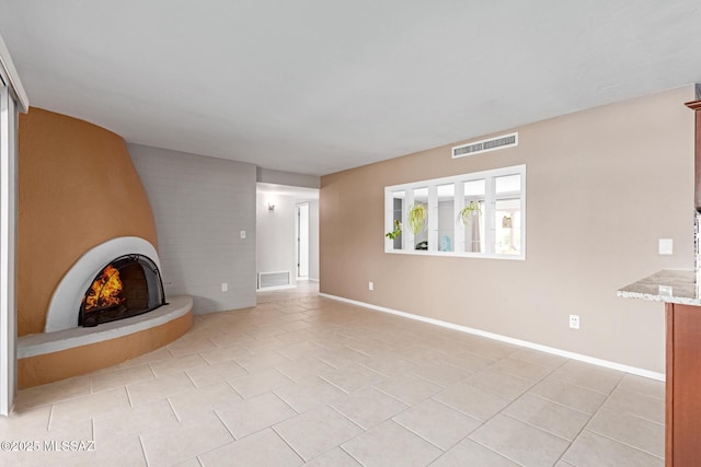 unfurnished living room featuring visible vents, baseboards, and a fireplace