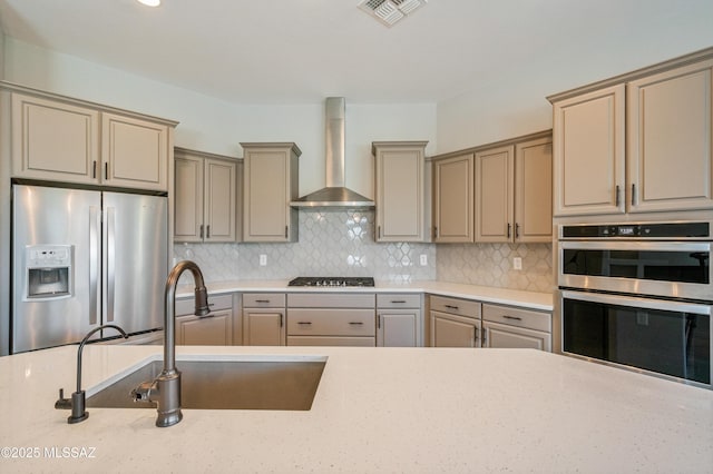 6909 W Cliff Spring Trl, Marana, AZ 85658 - kitchen with appliances with stainless steel finishes, wall chimney exhaust hood, a sink, and tasteful backsplash