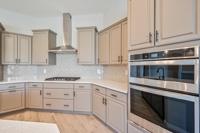 6909 W Cliff Spring Trl, Marana, AZ 85658 - kitchen featuring appliances with stainless steel finishes, wall chimney exhaust hood, light countertops, and backsplash