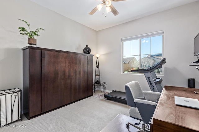 office space with baseboards, light carpet, and ceiling fan