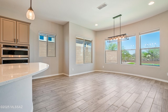 6909 W Cliff Spring Trl, Marana, AZ 85658 - kitchen with healthy amount of natural light, light wood finished floors, baseboards, and recessed lighting