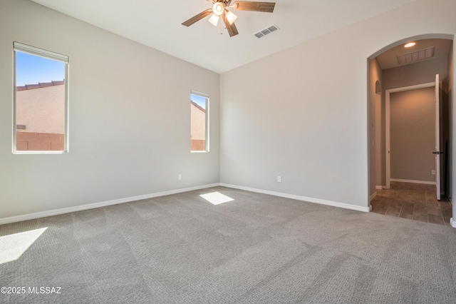 6909 W Cliff Spring Trl, Marana, AZ 85658 - carpeted spare room with arched walkways, ceiling fan, and baseboards