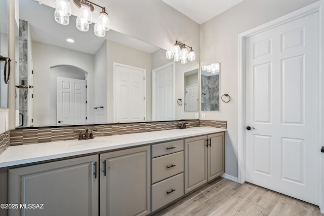 6909 W Cliff Spring Trl, Marana, AZ 85658 - full bath featuring double vanity, tasteful backsplash, wood finished floors, baseboards, and a chandelier