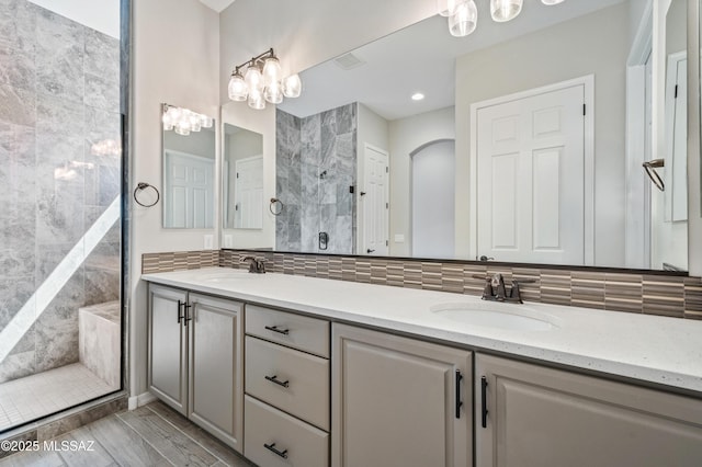 6909 W Cliff Spring Trl, Marana, AZ 85658 - full bath featuring tiled shower, double vanity, and decorative backsplash