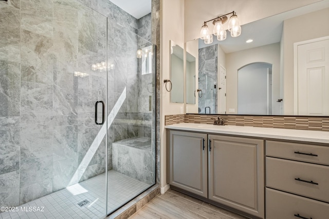 6909 W Cliff Spring Trl, Marana, AZ 85658 - bathroom featuring a shower stall, vanity, and wood finished floors