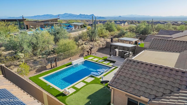 view of swimming pool featuring a fenced in pool, a mountain view, a fenced backyard, and a patio