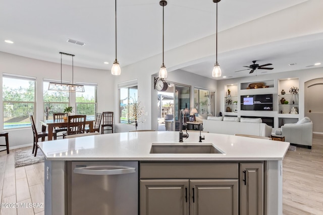 kitchen with visible vents, open floor plan, light countertops, light wood-style floors, and a sink