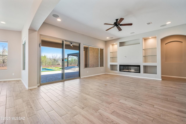 6909 W Cliff Spring Trl, Marana, AZ 85658 - unfurnished living room with a ceiling fan, baseboards, plenty of natural light, and recessed lighting