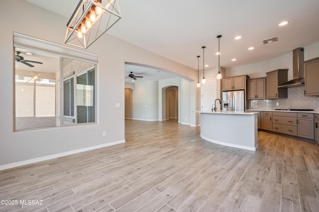 6909 W Cliff Spring Trl, Marana, AZ 85658 - kitchen featuring a ceiling fan, wall chimney range hood, stainless steel fridge with ice dispenser, gray cabinets, and recessed lighting