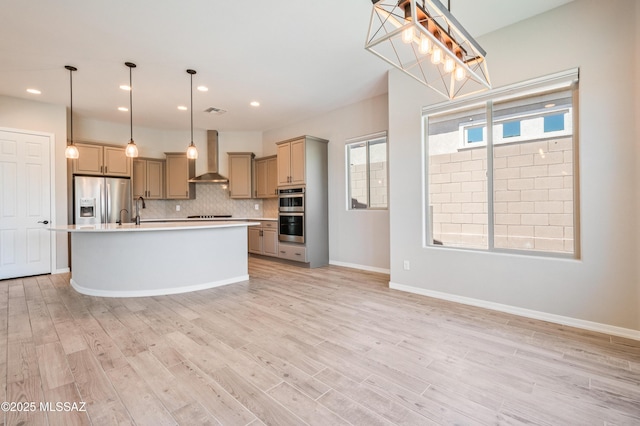 6909 W Cliff Spring Trl, Marana, AZ 85658 - kitchen with appliances with stainless steel finishes, wall chimney exhaust hood, light countertops, tasteful backsplash, and light wood-type flooring