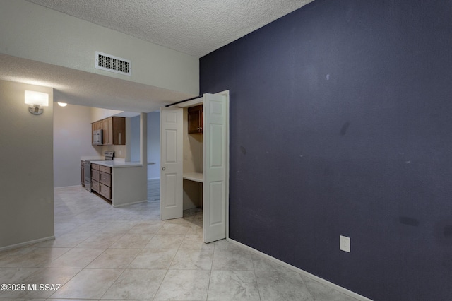 unfurnished bedroom featuring visible vents, baseboards, and a textured ceiling