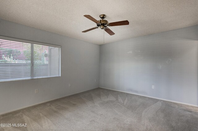 carpeted empty room with a textured ceiling and a ceiling fan