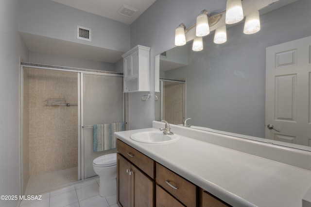 bathroom with visible vents, toilet, a tile shower, tile patterned floors, and vanity