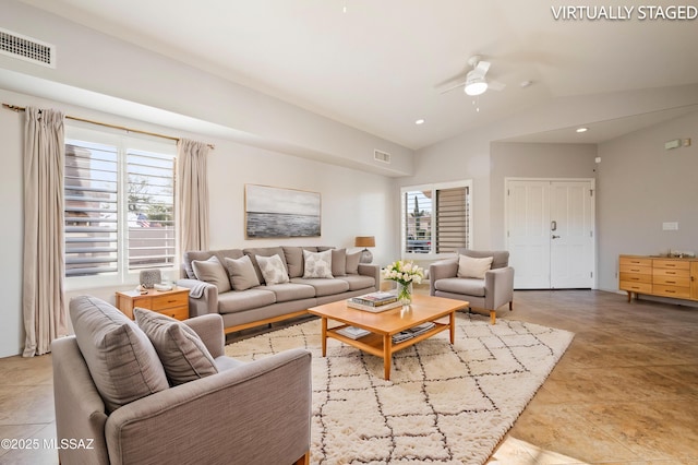 living room featuring a ceiling fan, visible vents, and a wealth of natural light