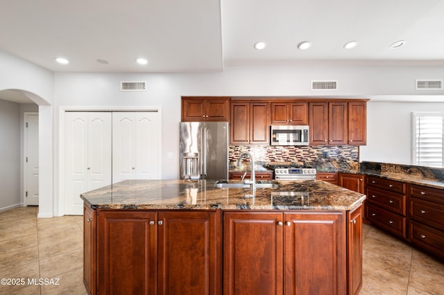 kitchen with a sink, visible vents, arched walkways, and appliances with stainless steel finishes