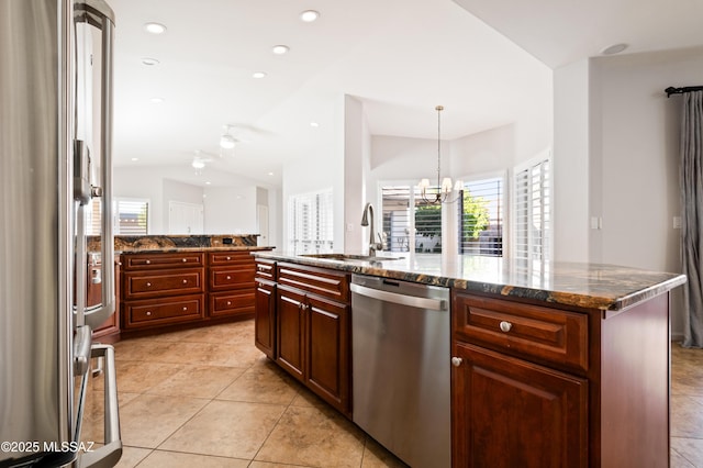 kitchen featuring a sink, recessed lighting, stainless steel appliances, dark stone counters, and vaulted ceiling