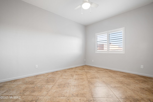 tiled empty room with baseboards and a ceiling fan