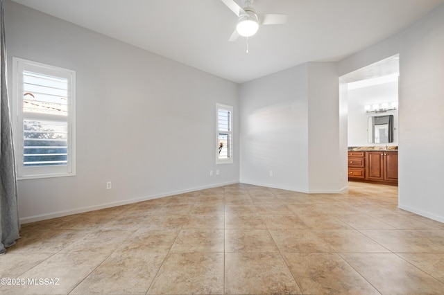 unfurnished room featuring baseboards, light tile patterned flooring, and a ceiling fan