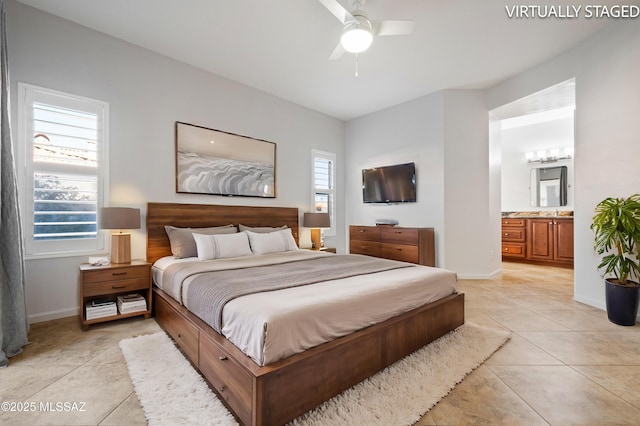 bedroom featuring light tile patterned flooring, a ceiling fan, baseboards, and ensuite bathroom