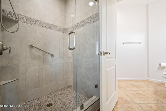 full bath with baseboards, a stall shower, and tile patterned flooring