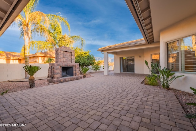 view of patio featuring an outdoor stone fireplace and fence