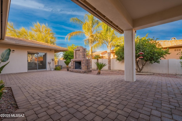 view of patio / terrace with an outdoor stone fireplace and fence