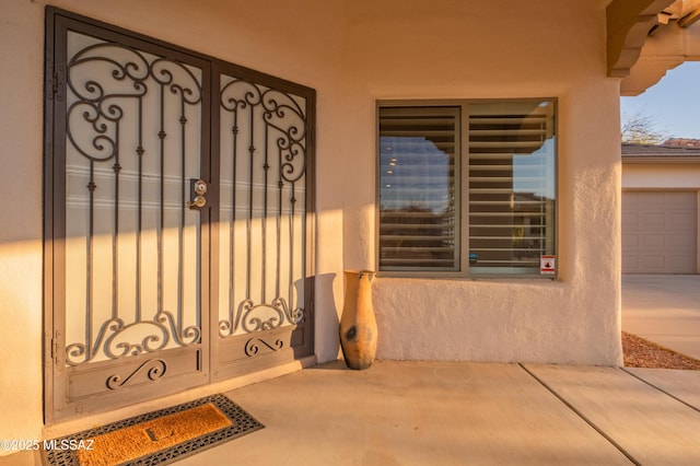 doorway to property featuring a gate and stucco siding