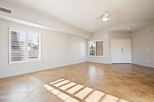 spare room with tile patterned flooring, vaulted ceiling, a ceiling fan, and visible vents