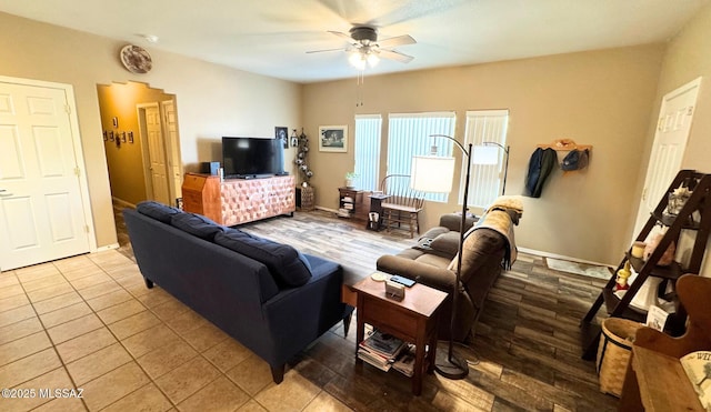 tiled living area with a ceiling fan and baseboards