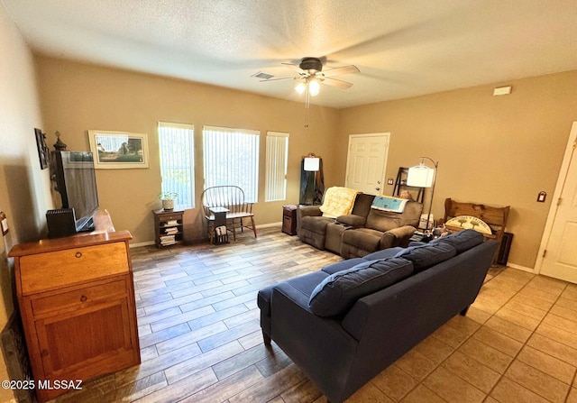 living area with baseboards, a textured ceiling, wood finished floors, and a ceiling fan