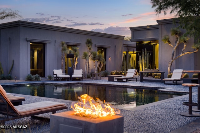 3978 N Canyon Ranch Dr, Tucson, AZ 85750 - pool at dusk featuring an outdoor fire pit, an outdoor pool, and a patio