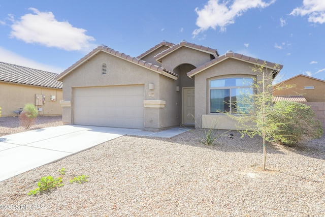 view of front of home featuring stucco siding, driveway, an attached garage, and a tile roof