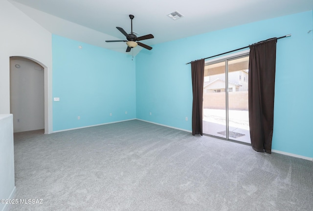empty room featuring a ceiling fan, visible vents, carpet floors, baseboards, and arched walkways