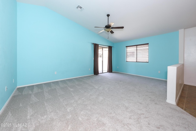 spare room with visible vents, carpet floors, baseboards, ceiling fan, and vaulted ceiling