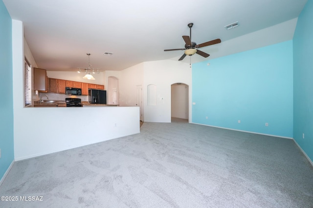 unfurnished living room with arched walkways, visible vents, a ceiling fan, and vaulted ceiling