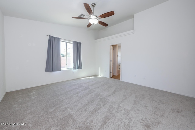 spare room with visible vents, lofted ceiling, carpet, and a ceiling fan