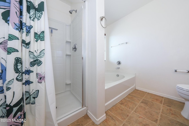 bathroom featuring a shower stall, toilet, a garden tub, and baseboards