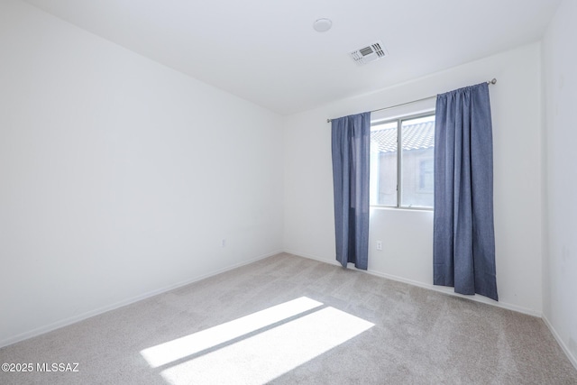 carpeted empty room featuring visible vents and baseboards