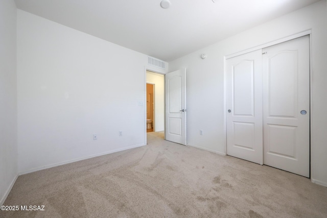 unfurnished bedroom with a closet, baseboards, visible vents, and carpet floors