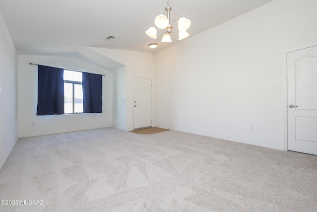 unfurnished room with an inviting chandelier, carpet, visible vents, and vaulted ceiling