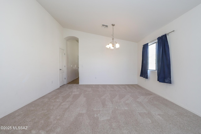 unfurnished room with a notable chandelier, arched walkways, visible vents, and carpet floors