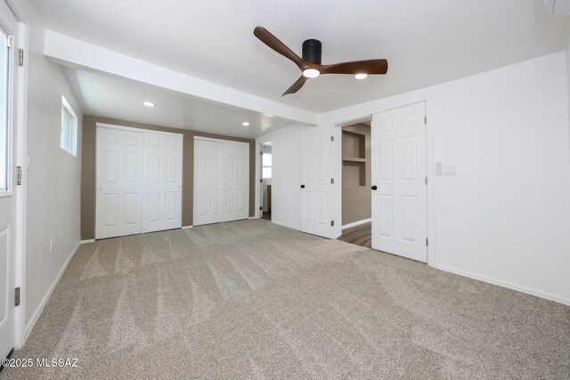 unfurnished bedroom with baseboards, carpet floors, recessed lighting, ceiling fan, and multiple closets