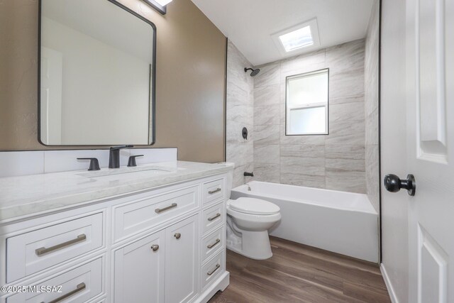 bathroom featuring washtub / shower combination, toilet, wood finished floors, and vanity