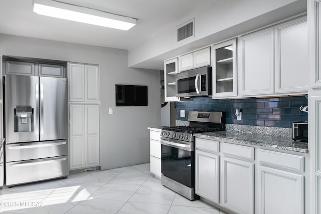 kitchen with visible vents, marble finish floor, stone countertops, appliances with stainless steel finishes, and decorative backsplash