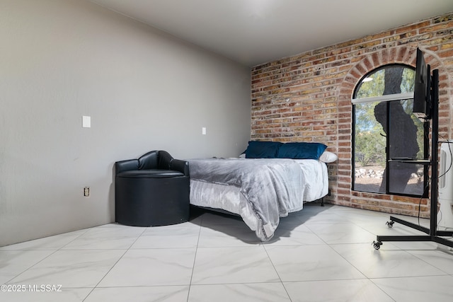 bedroom featuring brick wall