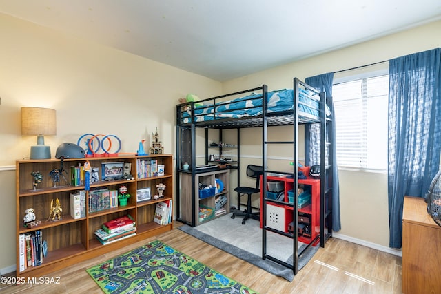 bedroom with baseboards and wood finished floors