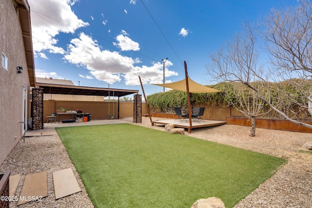 view of yard featuring a deck, a patio, and a fenced backyard