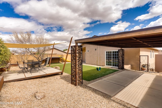 exterior space with a wooden deck, a patio, and fence