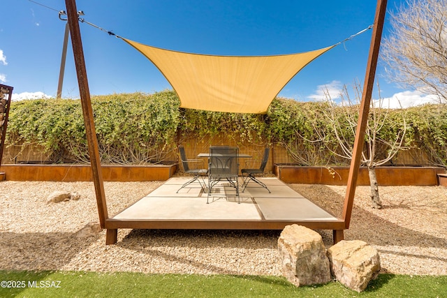 view of patio with a vegetable garden and a fenced backyard